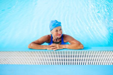 Spordan zevk alan yaşlı bir kadın canlılık ve uzun yaşam için yüzüyor. Son sınıf öğrencisi..