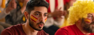 Stadyumda oynanan canlı futbol maçında İspanyol milli takımını destekleyen gergin futbol taraftarları.