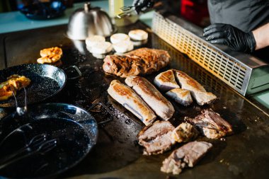 Şef lokanta mutfağında et ve sebze ızgara yapıyor..