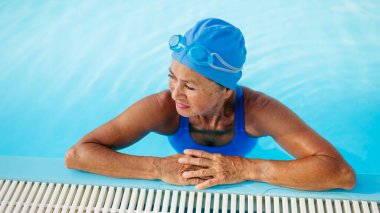 Spordan zevk alan yaşlı bir kadın canlılık ve uzun yaşam için yüzüyor. Son sınıf öğrencisi..