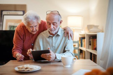 Tabletle çalışan kıdemli çift, bir doktordan online randevu alıyor..