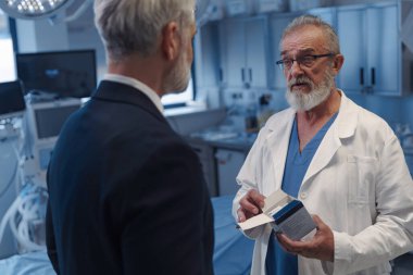 Tıbbi satış temsilcisi doktora yeni ilaç sunuyor. Hastane ayarları.