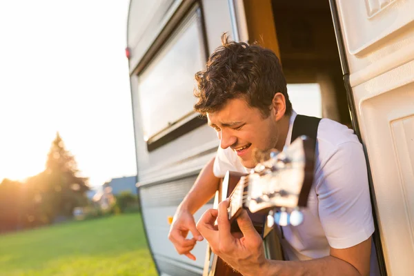 Young man sitting in a camper van — Stock Photo, Image