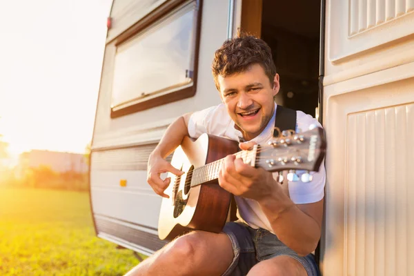 Young man sitting in a camper van — Stock Photo, Image