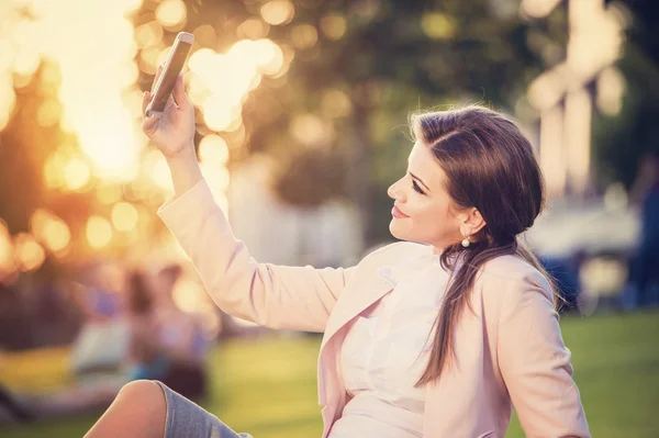 Business woman sitting in a park — Stock Photo, Image