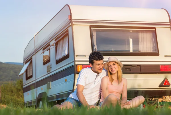 Pareja joven frente a una caravana — Foto de Stock