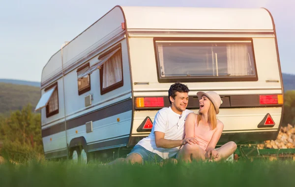 Pareja joven frente a una caravana — Foto de Stock