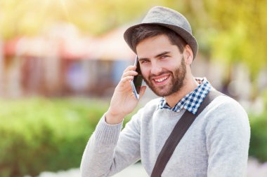 Genç adam akıllı telefon kullanıyor.