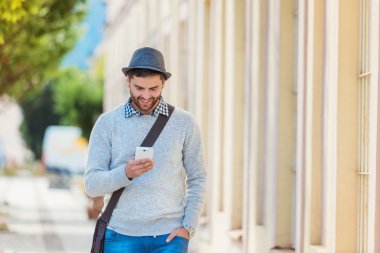 Genç adam akıllı telefon kullanıyor.