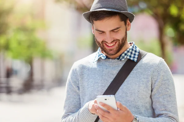 Genç adam akıllı telefon kullanıyor.