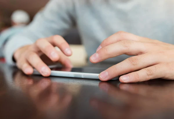 Hombre usando el teléfono inteligente en la mesa —  Fotos de Stock