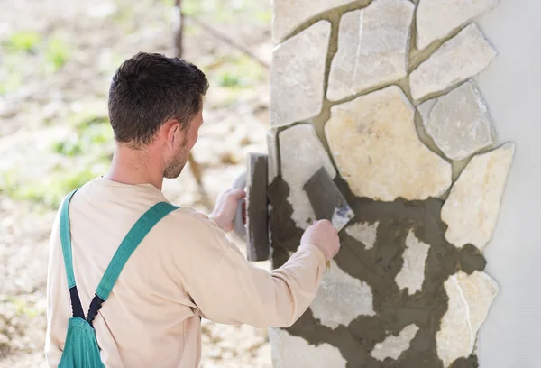 Builder putting stones on wall — Stock Photo, Image