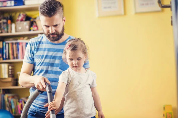 Father and daughter vacuuming floor — Stock Photo, Image