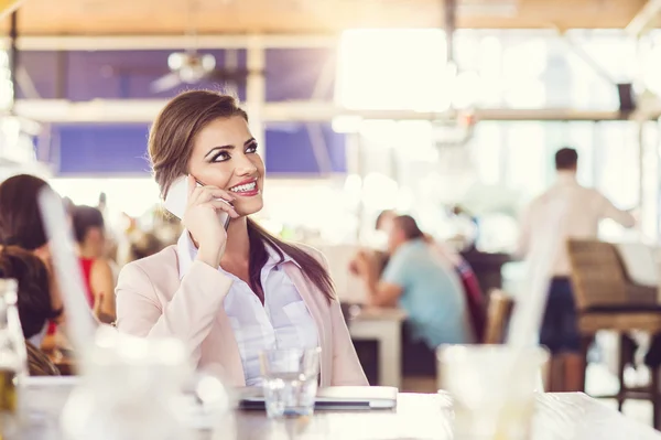 Affärskvinna med telefon i café — Stockfoto