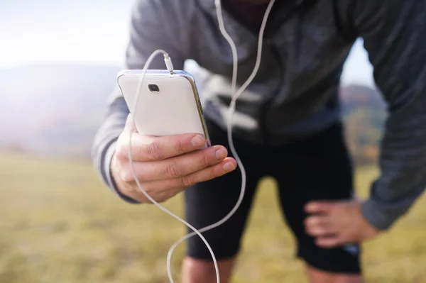 Löpare man med telefonen — Stockfoto