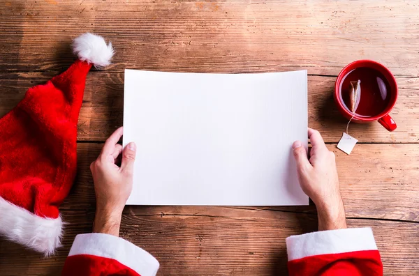 Papai Noel segurando wishlist — Fotografia de Stock