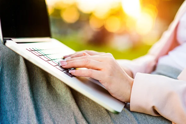 Business woman sitting in park — Stock Photo, Image