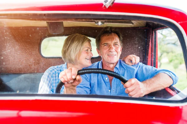 Couple sénior en voiture rouge — Photo