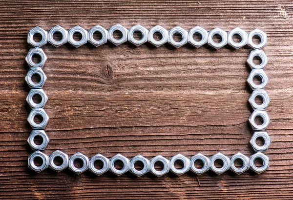 Chrome nuts on wooden background — Stock Photo, Image