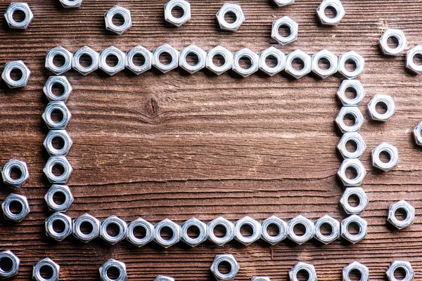 Chrome nuts on wooden background — Stock Photo, Image