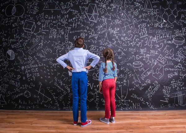 Schattige kleine jongen en meisje voor een grote bord. — Stockfoto