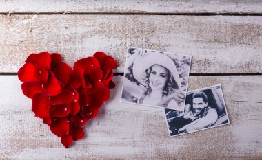 Photos of a couple in love. Red rose petal heart.