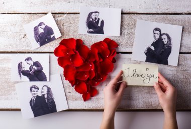 Mans hands. His and his girlfriends photo. Rose petal heart.