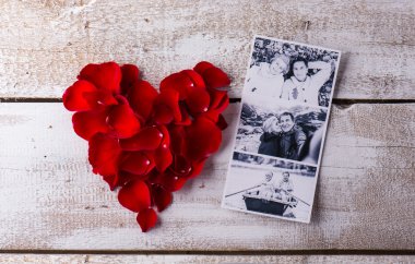 Photos of a couple in love. Red rose petal heart.
