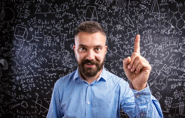 Profesor regañando contra pizarra grande con símbolo matemático —  Fotos de Stock