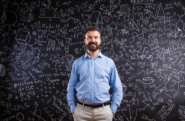 Hipster profesor contra pizarra grande con símbolos matemáticos — Foto de Stock