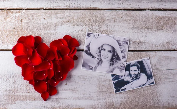 Photos of a couple in love. Red rose petal heart. — Stockfoto