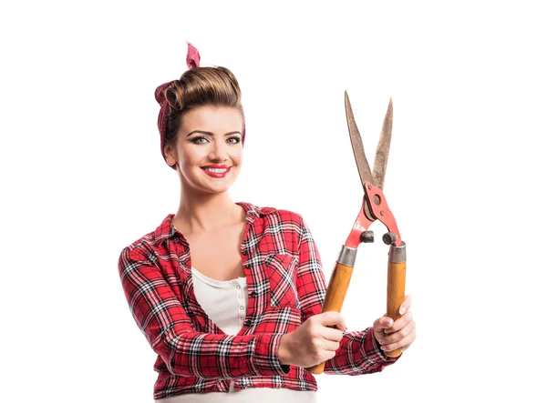 Woman with pin-up make-up and hairstyle holding pruning shears — Stock Photo, Image
