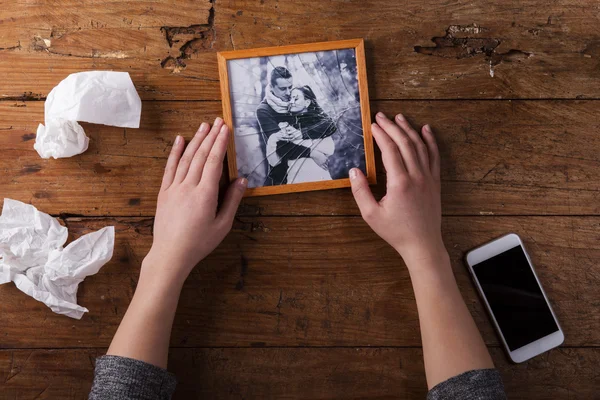 Mujer triste irreconocible sosteniendo imagen rota de pareja enamorada . —  Fotos de Stock