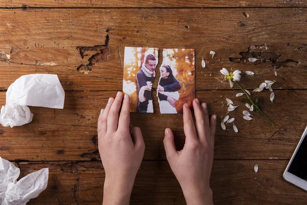 Unrecognizable sad woman holding torn picture of couple in love. — Zdjęcie stockowe