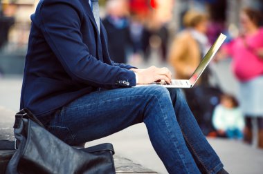 Unrecognizable manager working on laptop on crowded Piccadilly C