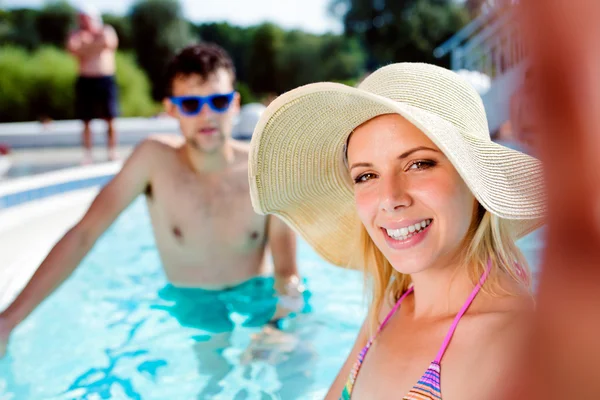 Casal na piscina a tirar selfie. Verão e água . — Fotografia de Stock