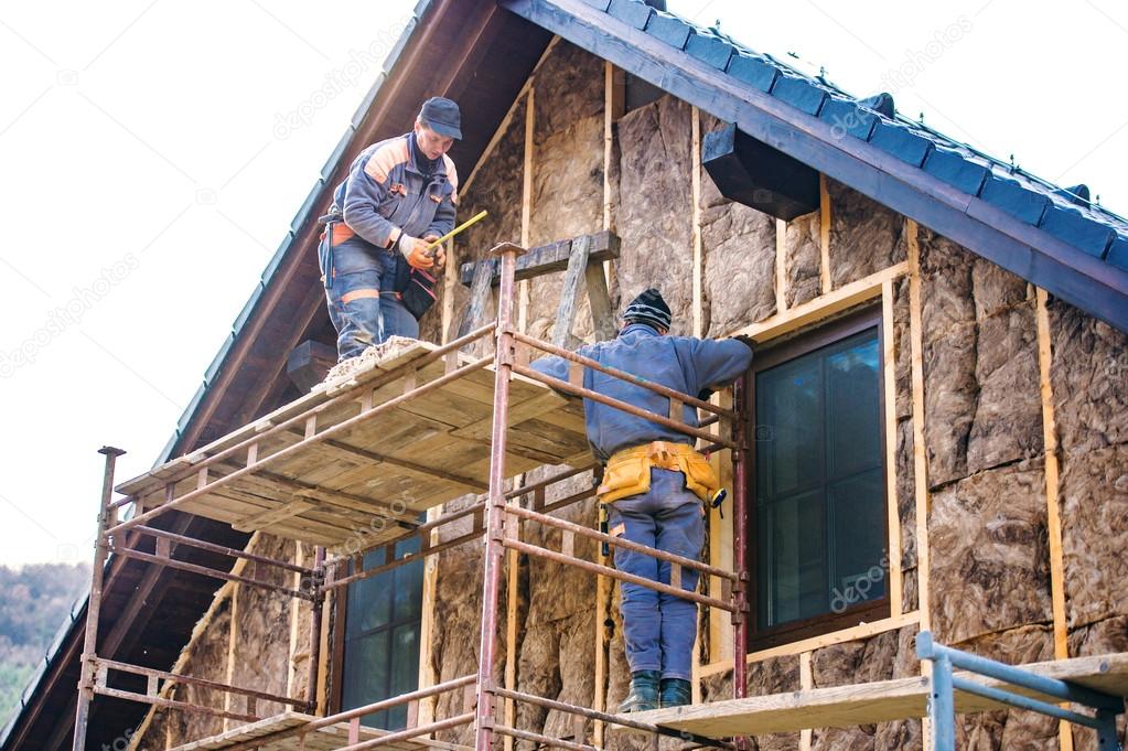 Construction workers insulating house