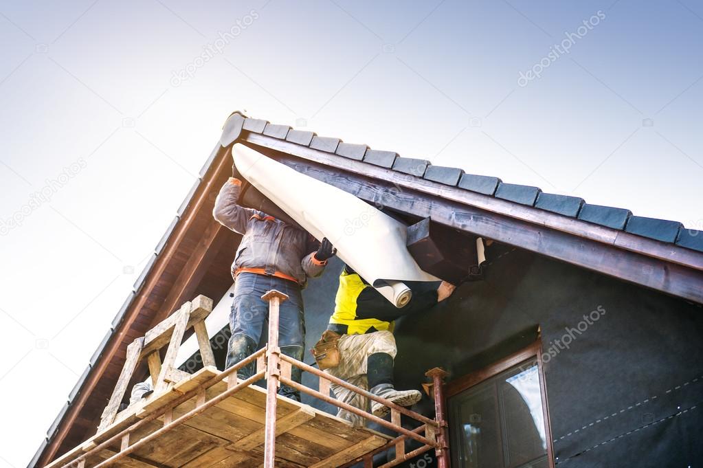 Construction workers insulating house