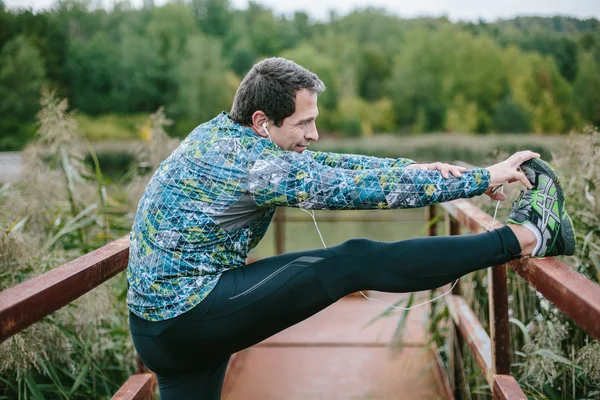 Löpare stretching i naturen — Stockfoto