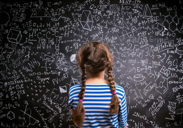 Девушка против большой доски с формулами, вид сзади — стоковое фото