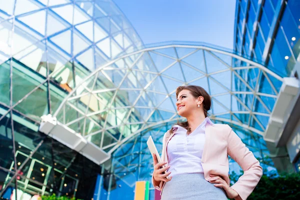 Businesswoman holding a tablet against glassy modern office buil — Φωτογραφία Αρχείου