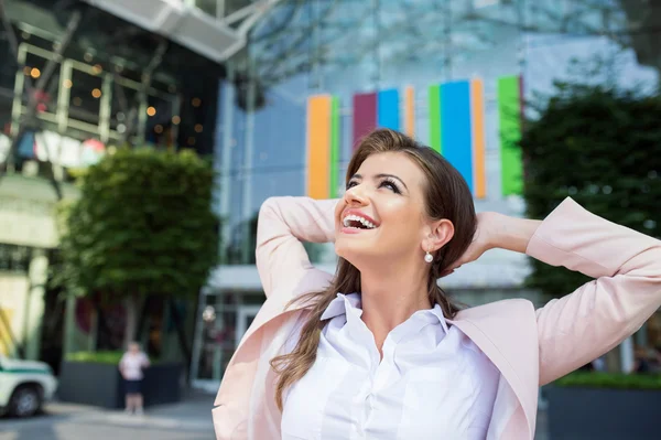 Smiling businesswoman with hands on head against modern building — Stock fotografie