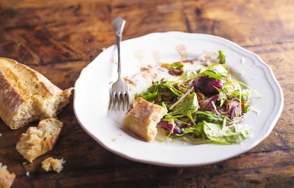 Insalata di rucola su piatto di porcellana bianca con pane brusheta — Foto Stock