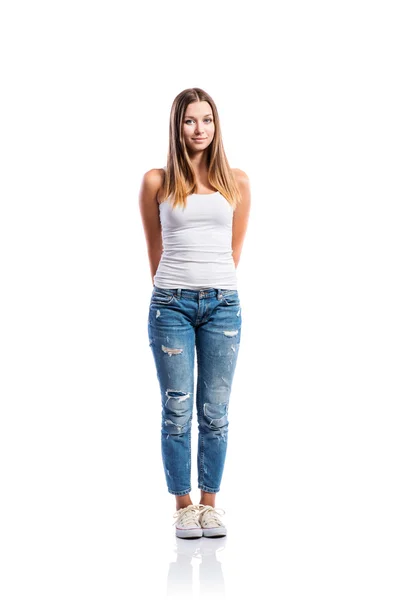 Стоящая девочка-подросток в джинсах и белом сингле, изолированная — стоковое фото
