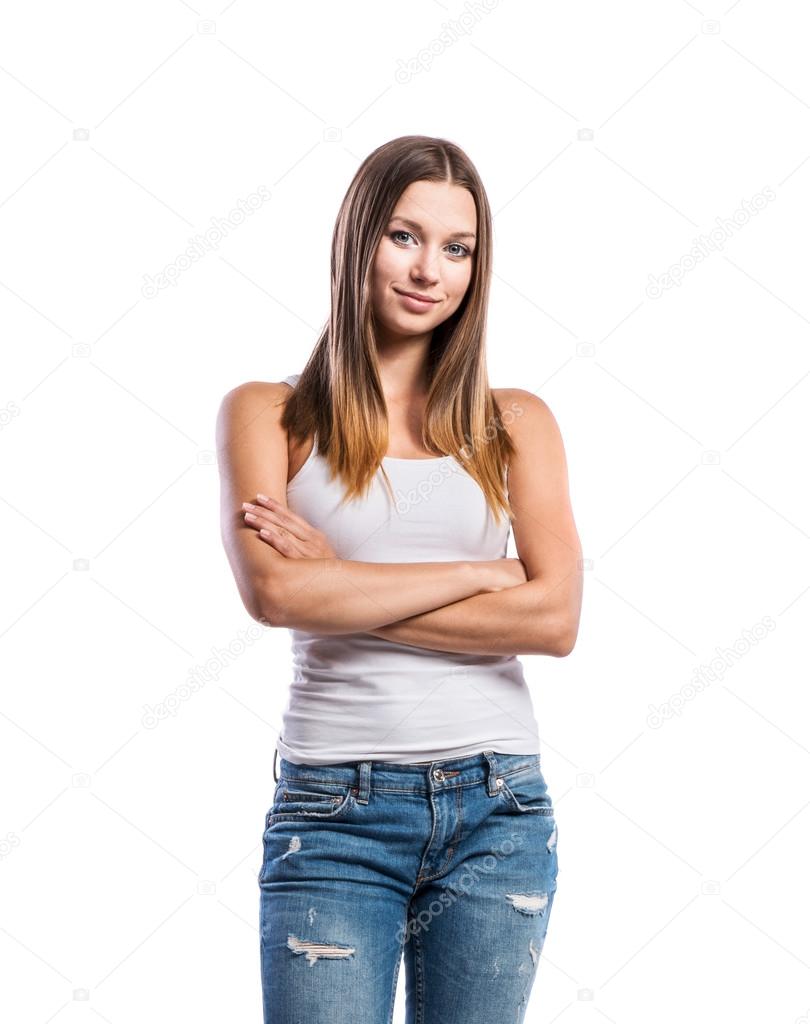 Standing teenage girl in jeans and white singlet,  isolated