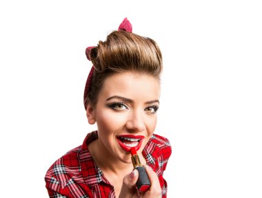 Woman with pin-up make-up and hairstyle applying red lipstick