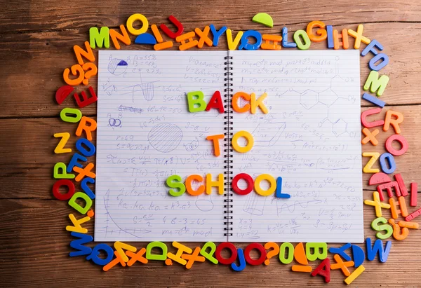 Lettres en plastique colorées, retour à l'école, carnet avec formules — Photo