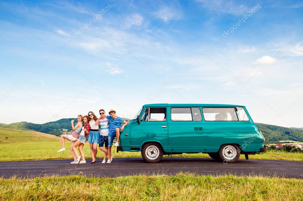 Young frieds with campervan, green nature and blue sky