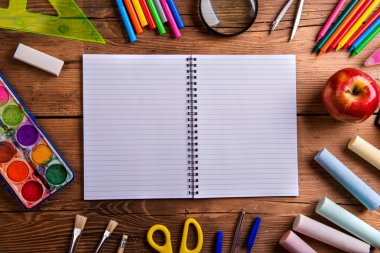 Desk, school supplies, lined paper, wooden background, copy spac
