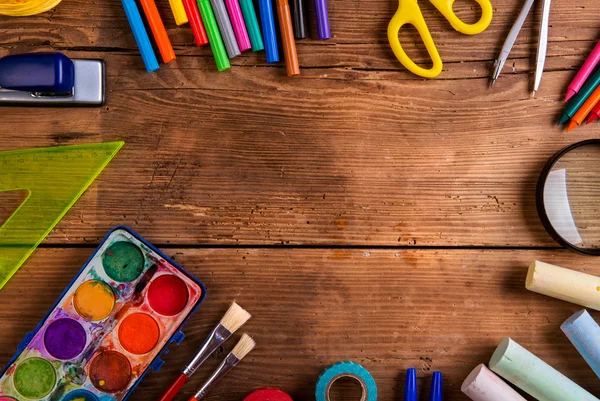 Desk with school supplies against wooden background, copy space — Stok fotoğraf